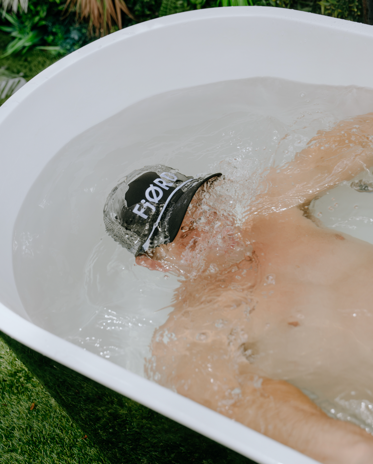 Close-up of a FjØRD beanie above icy water in a white plunge tub