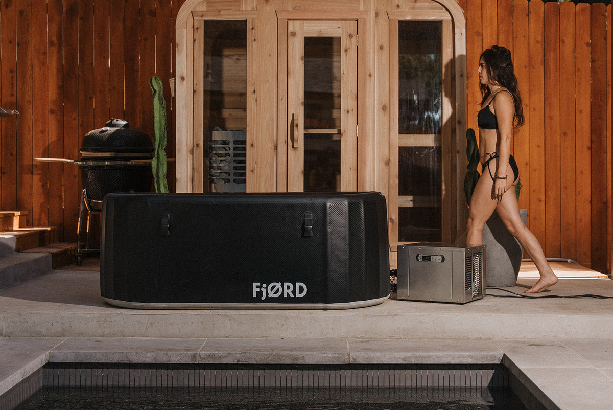 FjØRD Sport cold plunge with its cover on, outside a timber-clad home